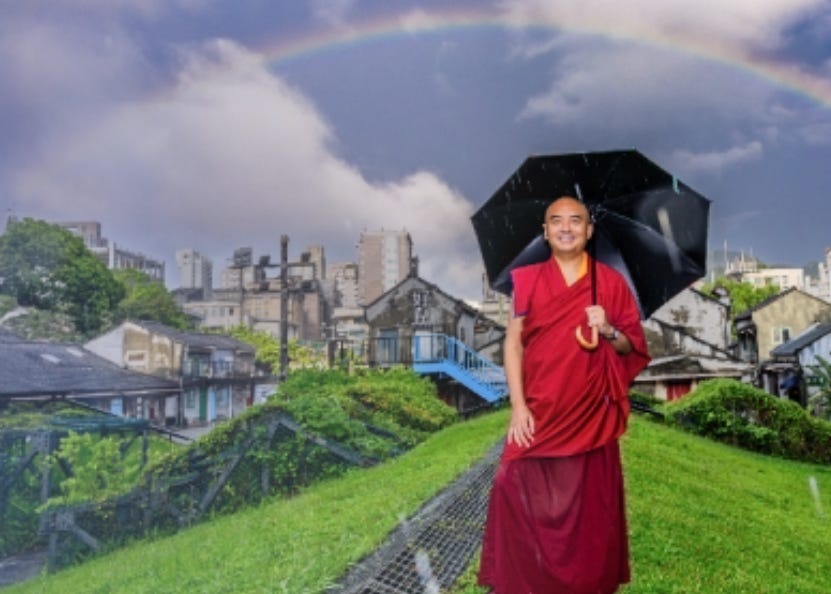 Photo of Mingyur Rinpoche walking with an umbrella under a rainbow