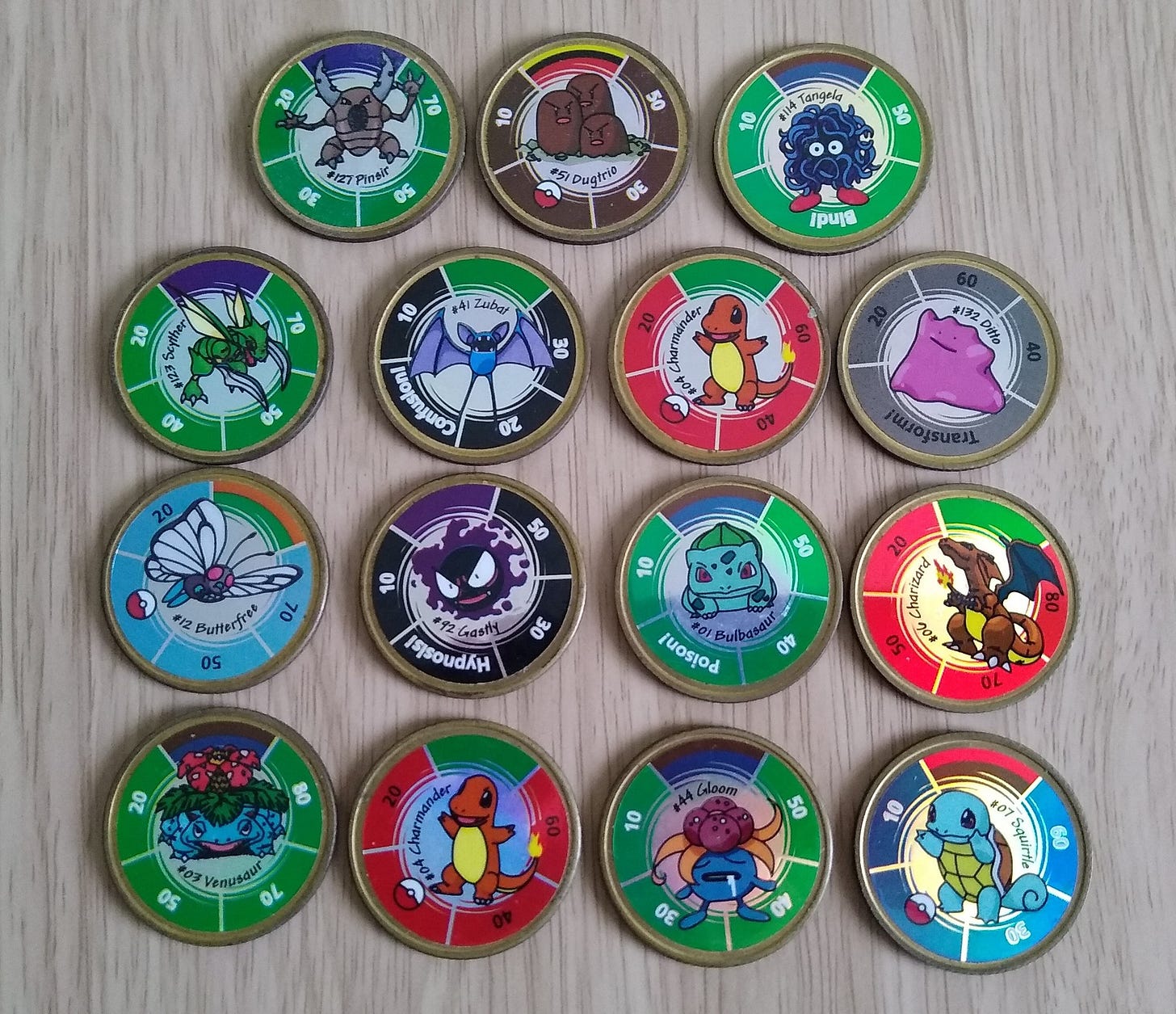 Fifteen Pokémon Battling Coins from my collection, featuring a variety of Pokémon characters found in Kanto