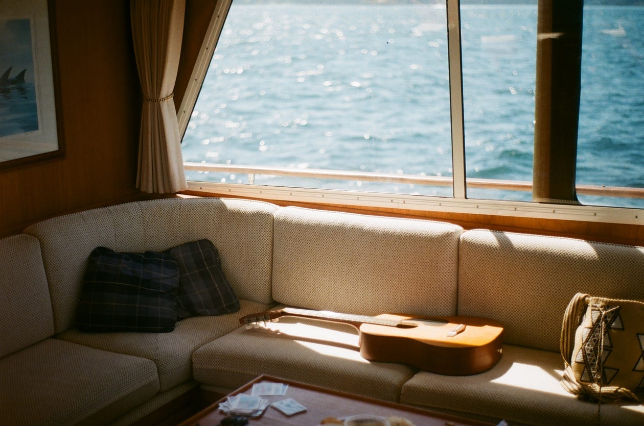 Guitar on the couch on a boat in a beam of sun