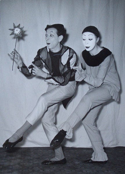 Two mimes tip-toeing across the stage