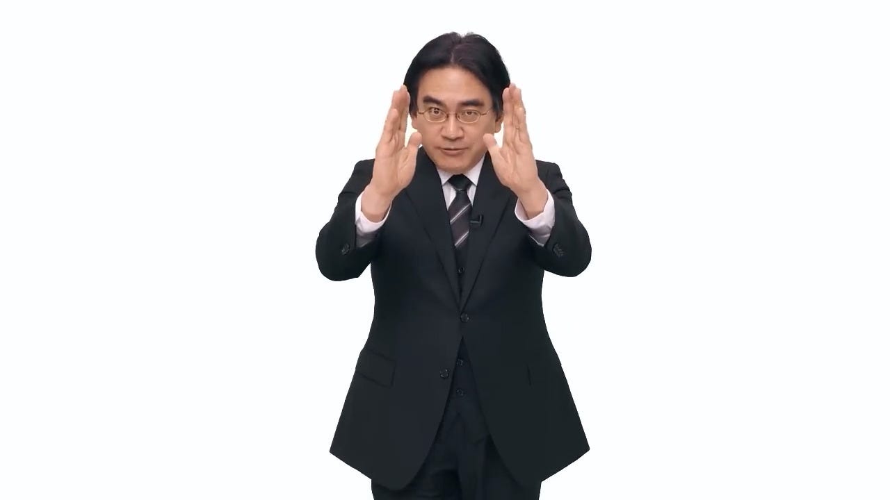 Satoru Iwata striking his famous "Directly to You" pose during Nintendo Direct, in February 2014