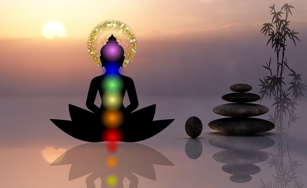 an outline of a meditating person with the chakras represented by colored lights.