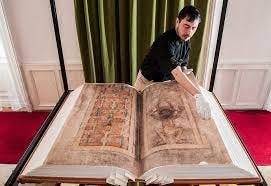 Image of a man paging through an enormous book