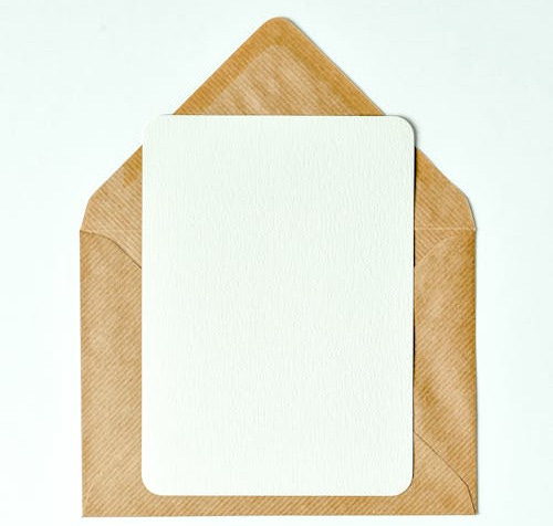 Free Minimalist blank card on a brown envelope for versatile use and mockups. Stock Photo