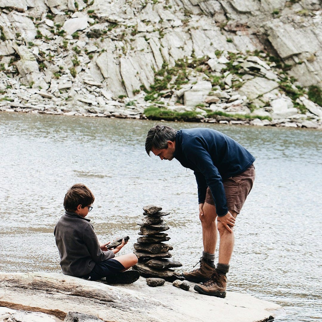boy and man beside river during daytime