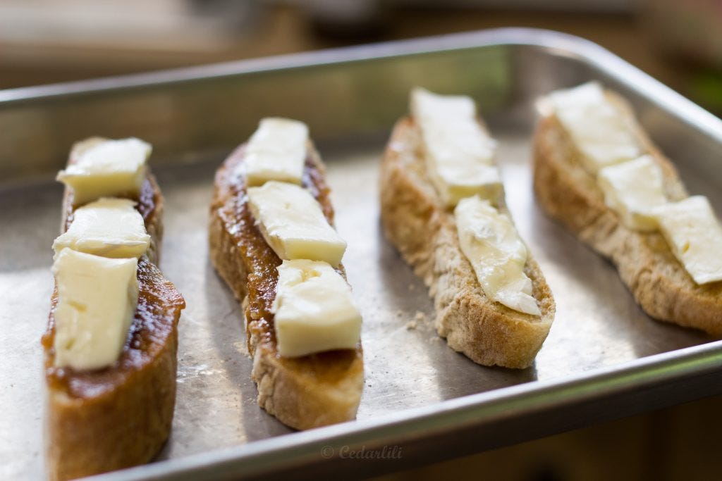 Brie, with the crust off, on the open-face sandwiches ready to go in the oven. 