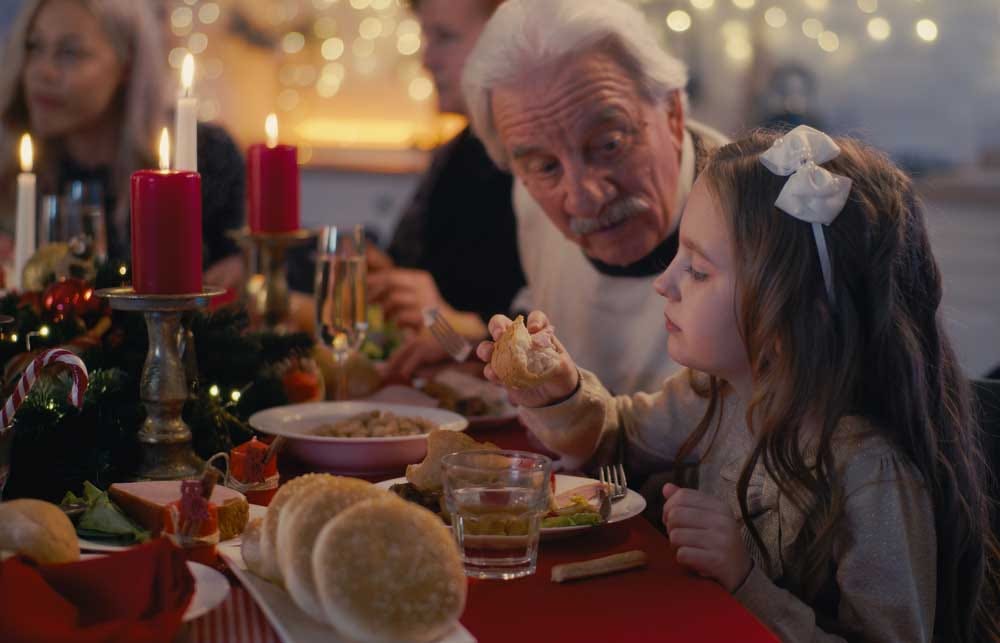 Grandfather talking with grandchild over a delicious Christmas meal.