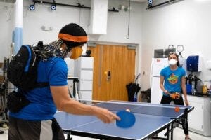 A participant plays table tennis against graduate student Amanda Studnicki while having his brain imaged via an EEG cap. The experiment revealed big differences in how our brains respond to human and machine opponents during sports.