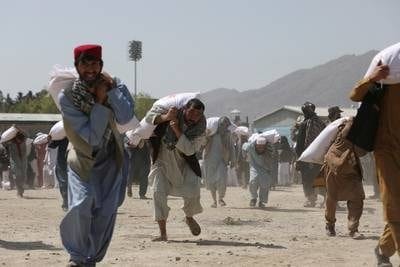 Afghans carry sacks of rice donated by China at a distribution centre in Kabul, Afghanistan, in April 2022. Reuters