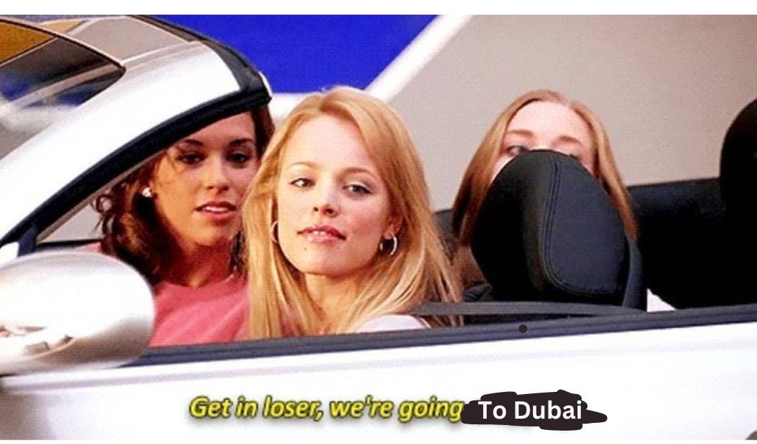 Scene from the movie "mean girls" 3 women are in a car and looking towards the photographer. The text at the bottom of the original version of the image says "get in loser, we're going shopping". But for the sake of the story, it has been changed to a meme text that says "get in loser, we're going to Dubai". The "shopping" is blacked out with black ink and replaced with "to dubai" to make the edit obvious.
