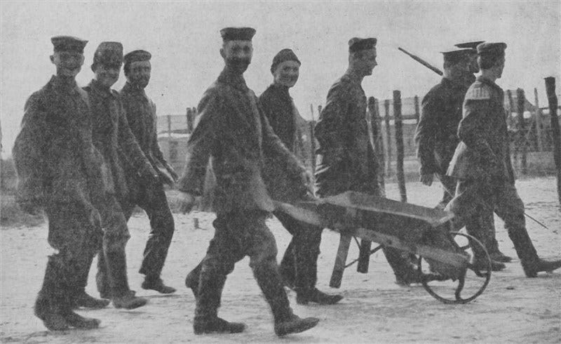 Grainy photo of nine German prisoners going about their business. One is pushing a wheelbarrow. They look pretty cheery despite being prisoners in Scotland.