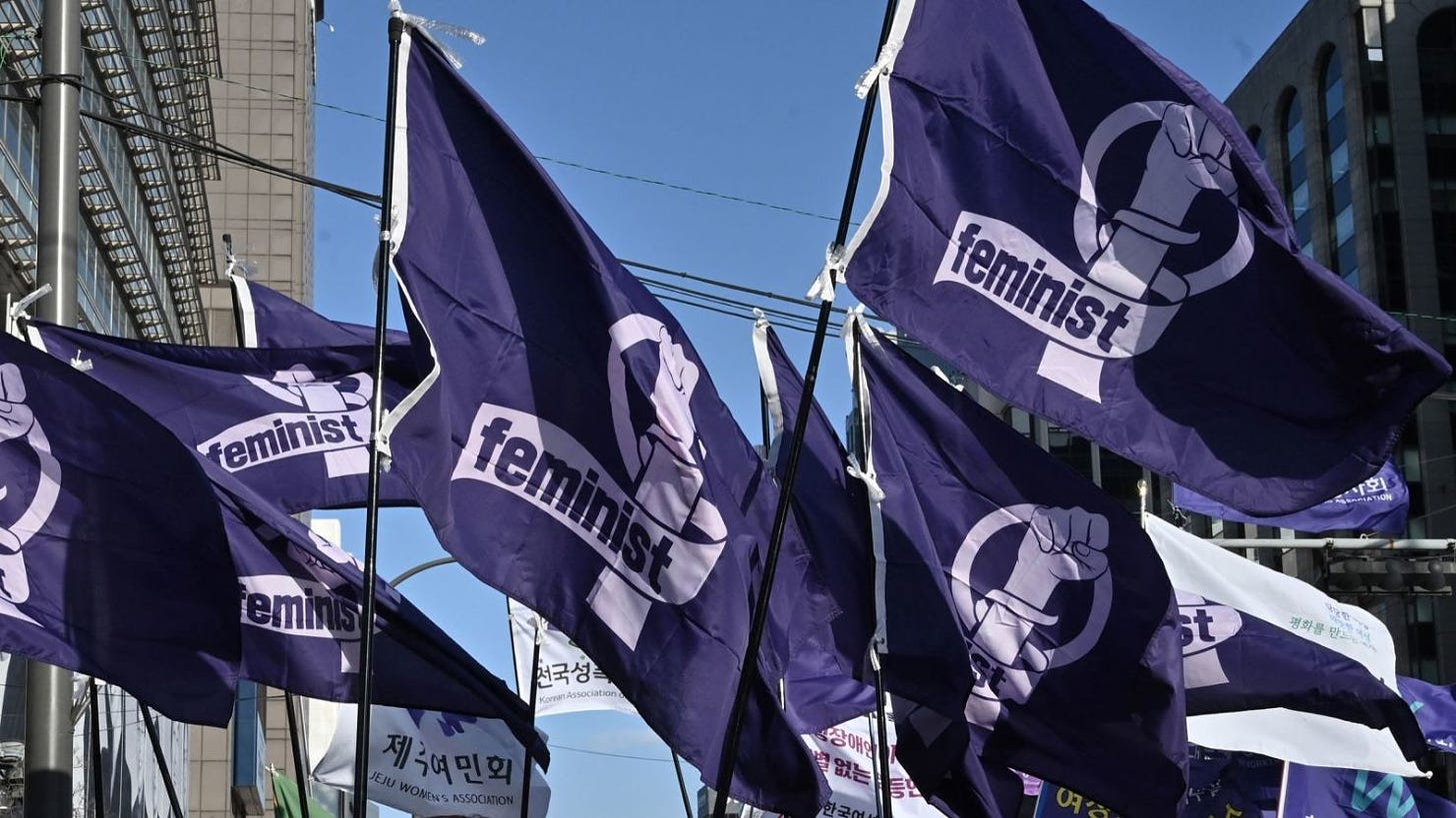 Mujeres surcoreanas llevan banderas con la leyenda "feminista" durante una manifestación en Seúl a principios de este año para conmemorar el Día Internacional de la Mujer.