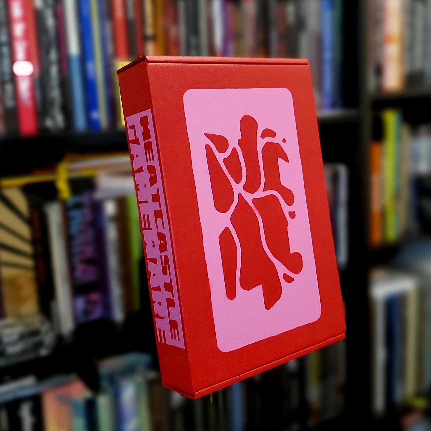 A red box with pink MCGW logo on the front and MCGW wordmark on the spine
