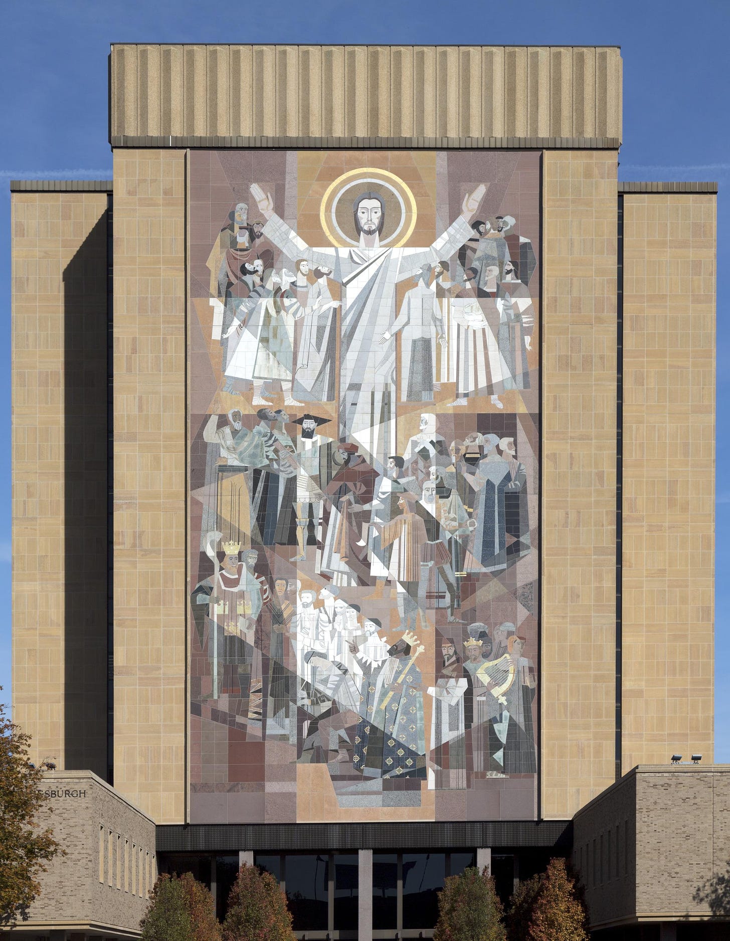 Mural on a building at Notre Dame with Jesus holding his hands up in a gesture that also looks like how you signal a touchdown in American football