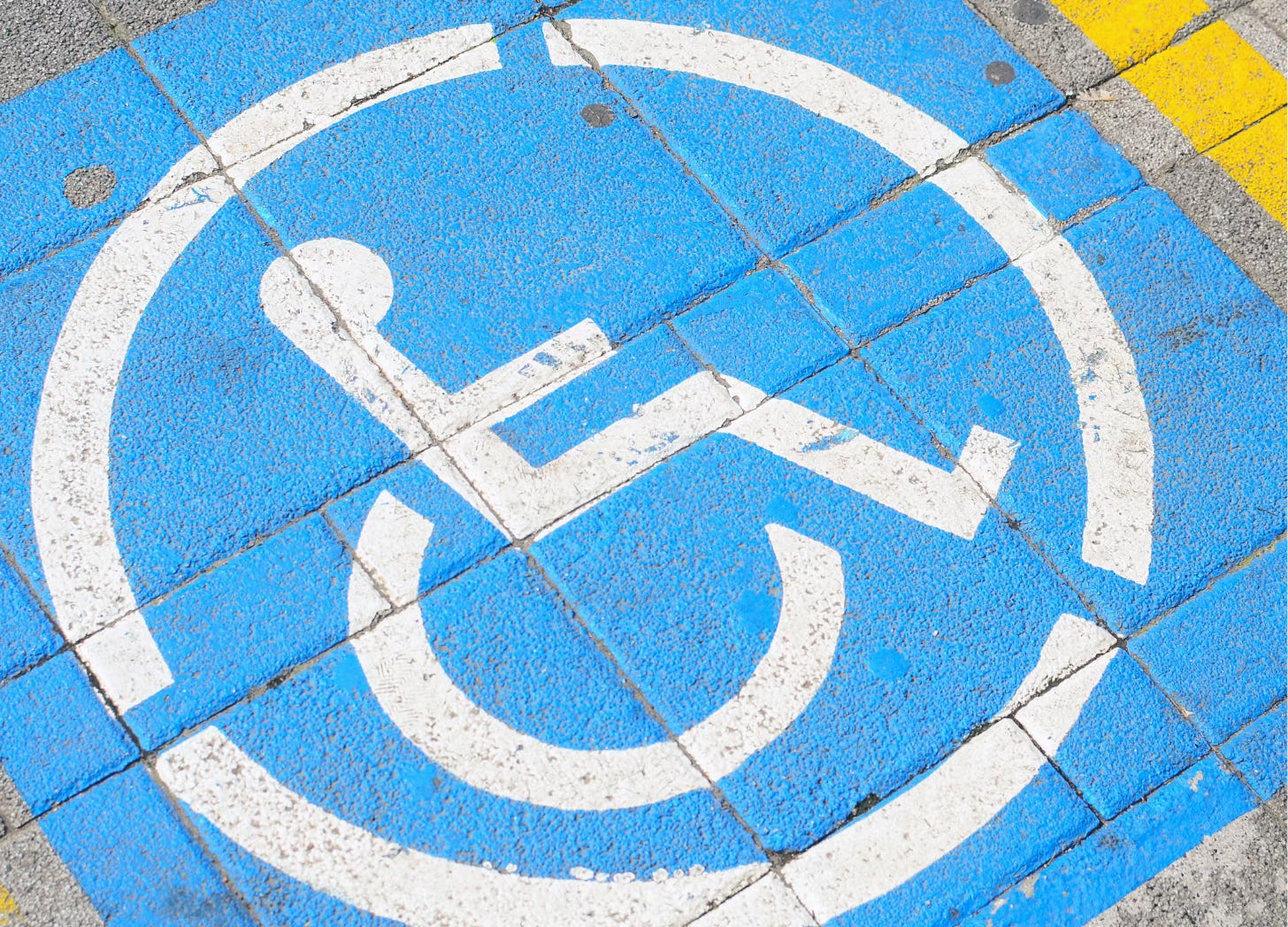 Wheelchair symbol painted on tiled pavement
