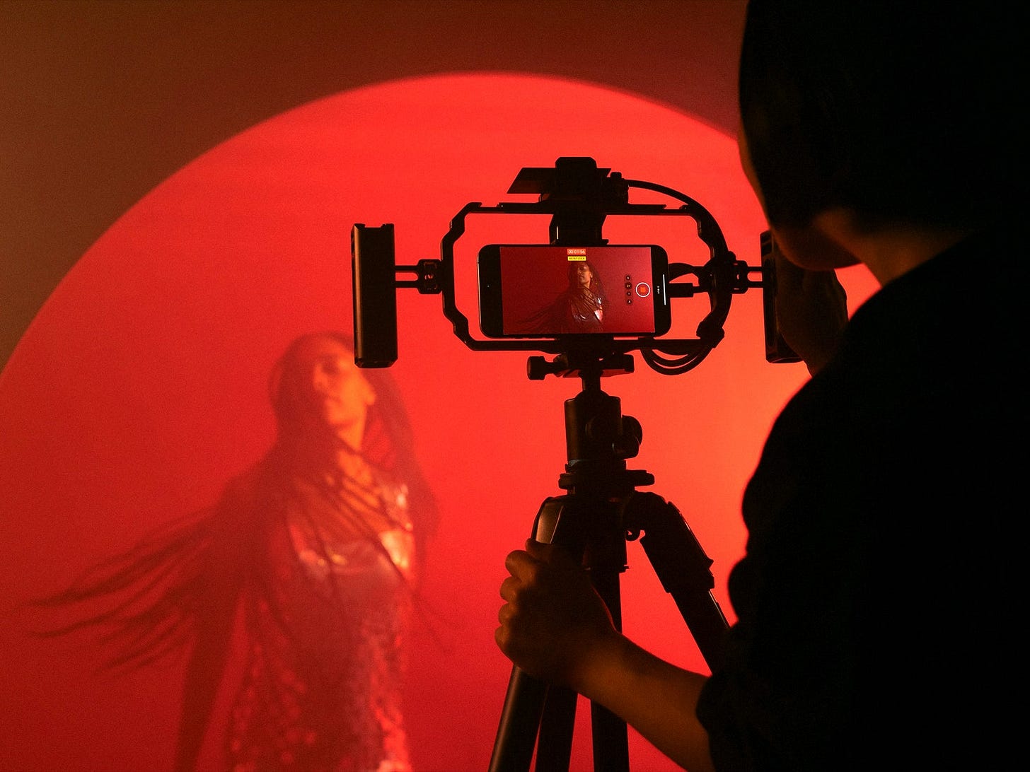 Person dancing in red light and being filmed with an iPhone 15 Pro Person dancing in red light and being filmed with an iPhone 15 Pro