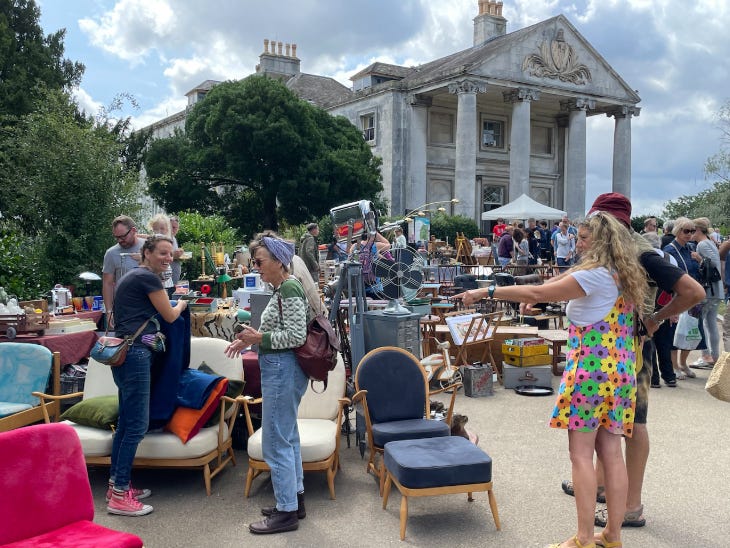 People looking at furniture at an outdoor vintage market People looking at furniture at an outdoor vintage market
