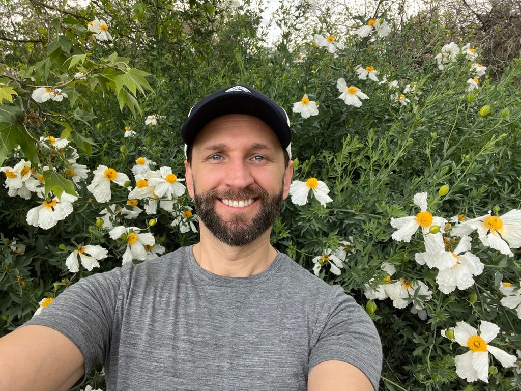 A person taking a selfie in front of flowers

Description automatically generated