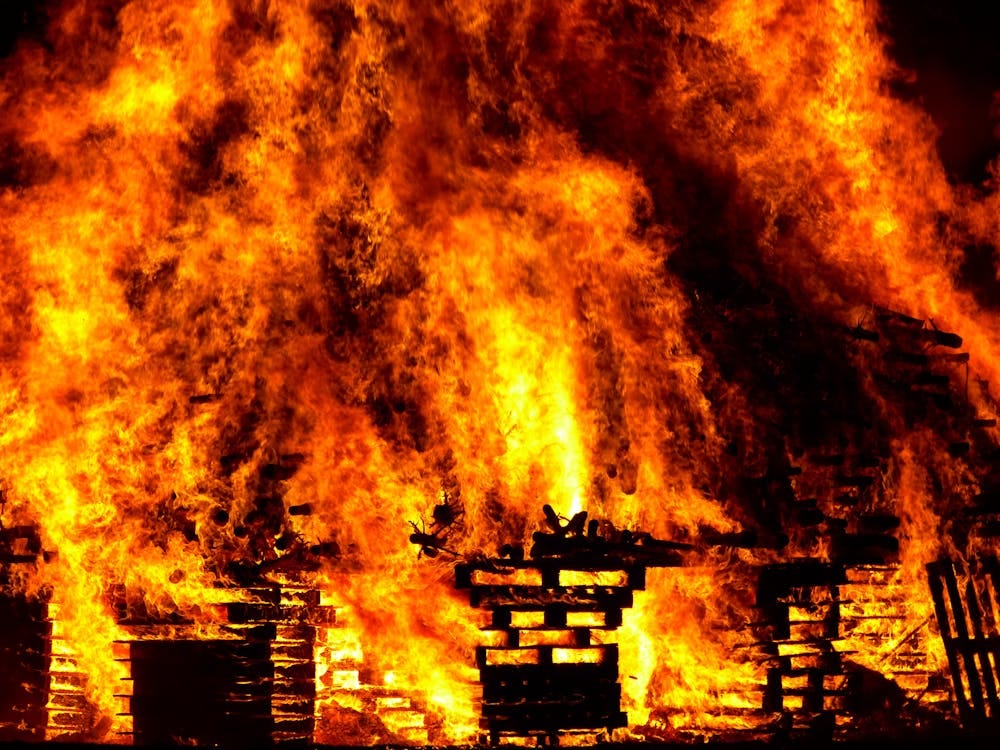 Large fire consuming stacks of wooden pallets.