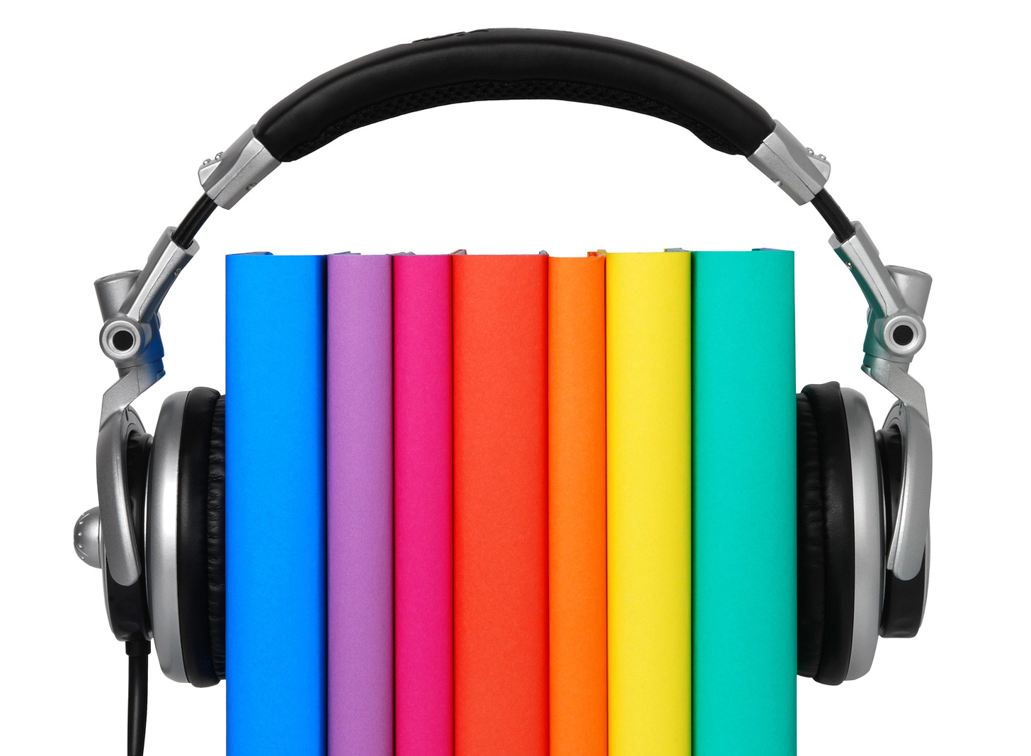 Seven books upright with headphones on them.