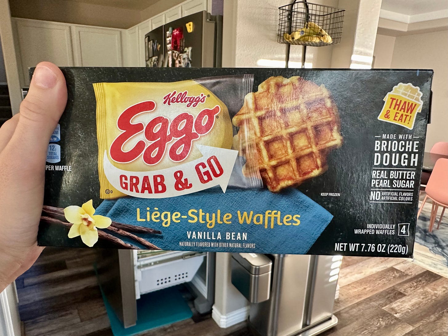 Shohreh's hand holding up a box of Eggo Grab & Go Liege-Style Waffles in Vanilla Bean