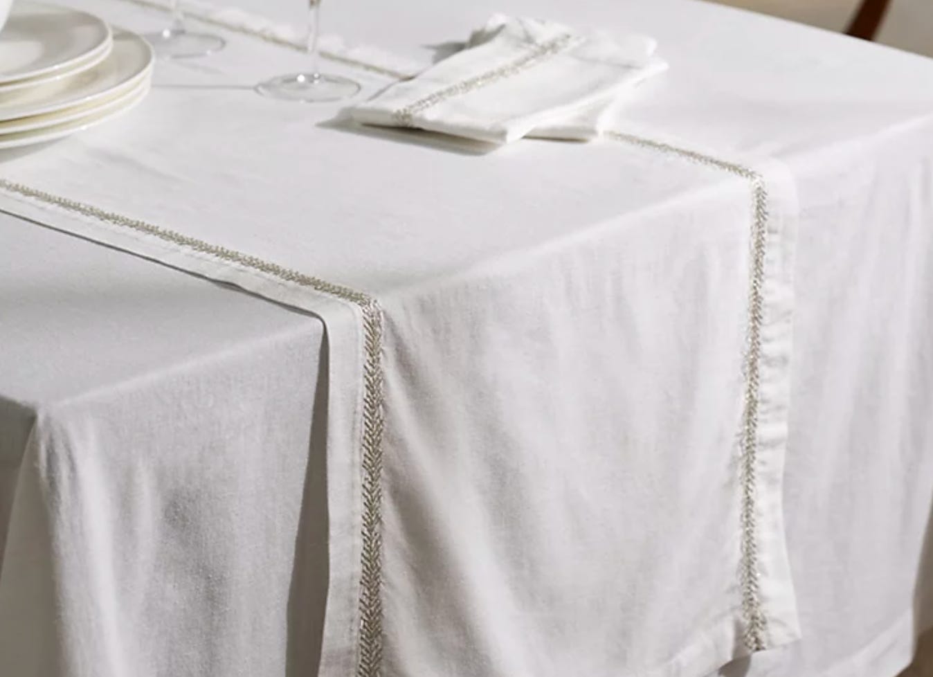 neutral table runner with silver feathered embroidered detailing to edge