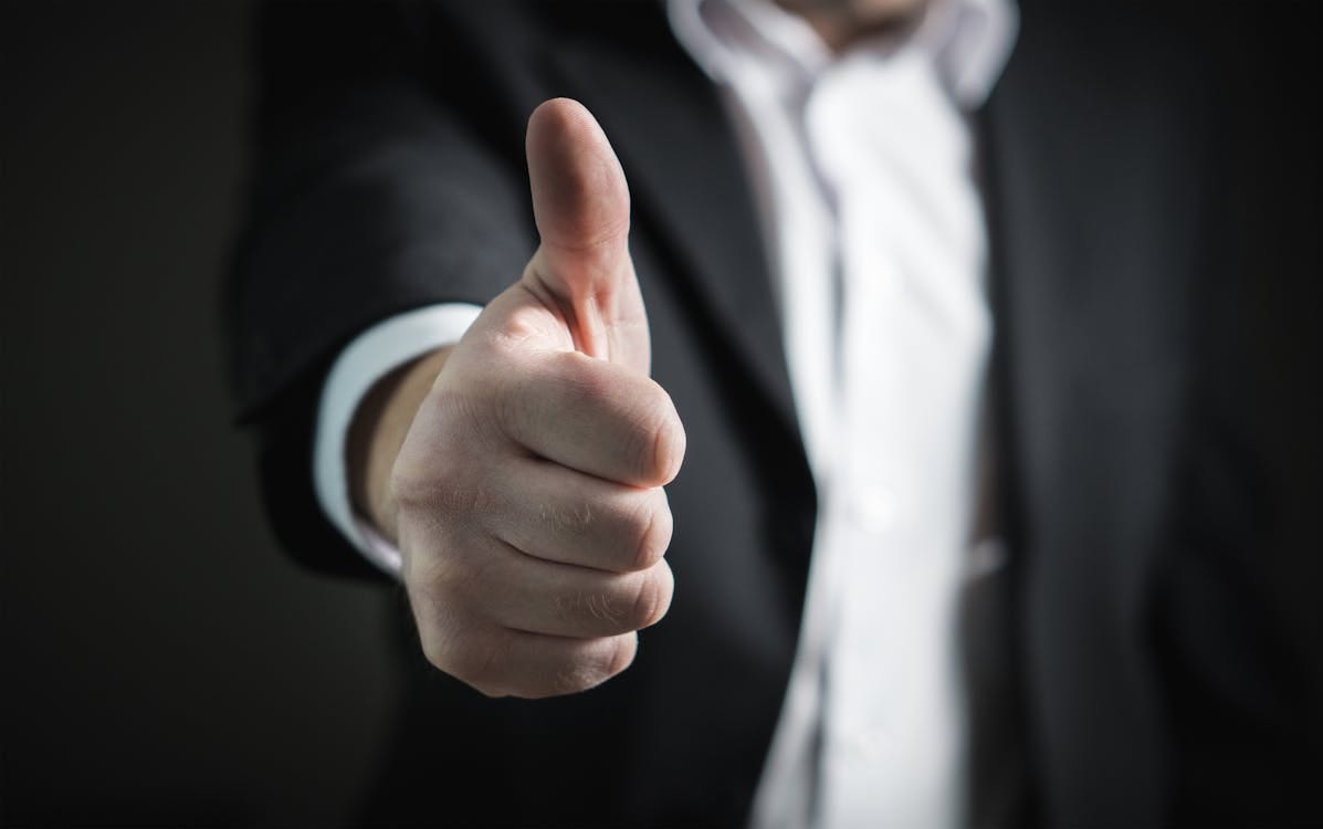 Free A close-up of a man's thumbs up gesture, symbolizing success and agreement. Stock Photo