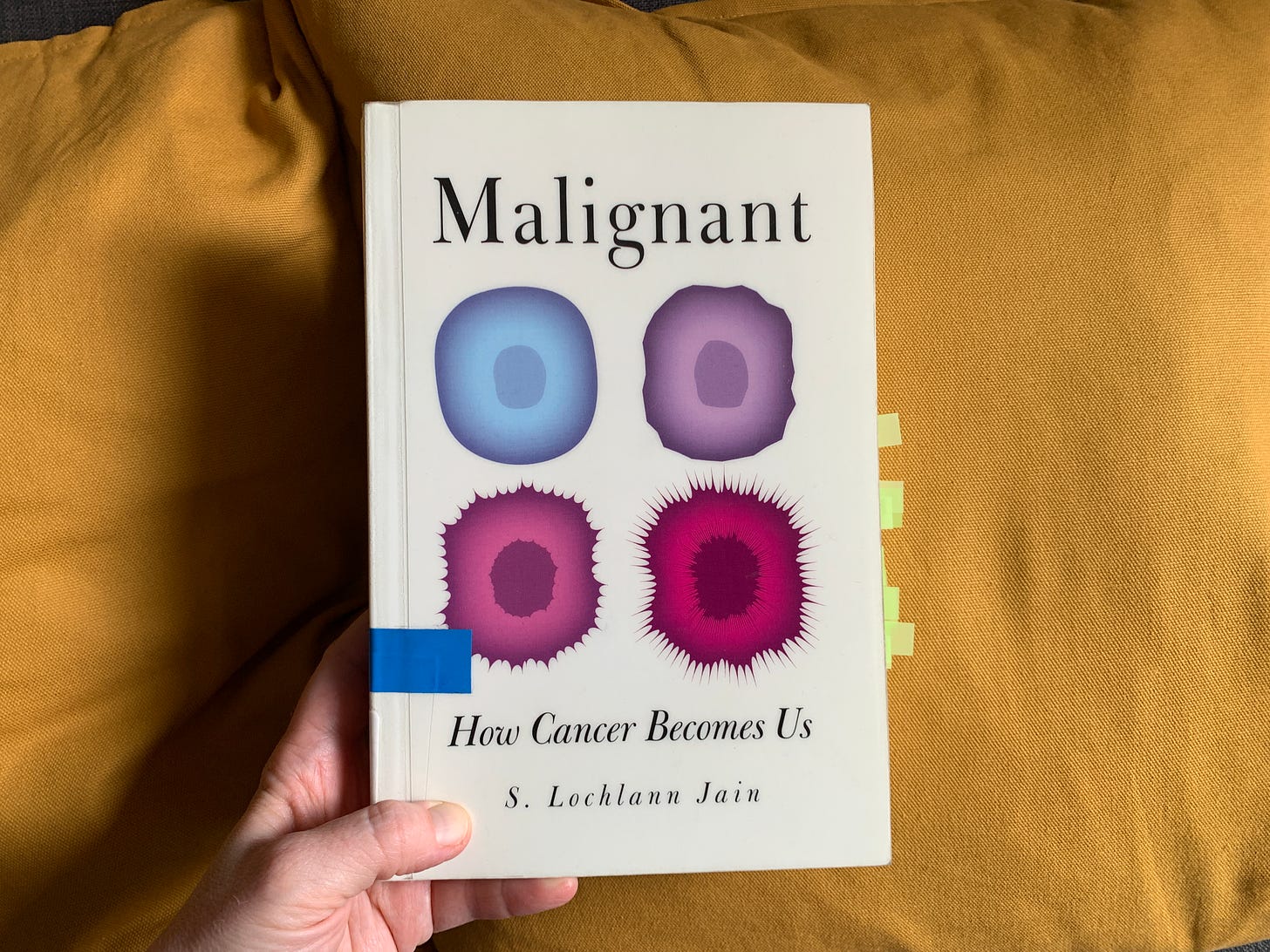 A photo of the front cover of the book Malignant on a mustard yellow background
