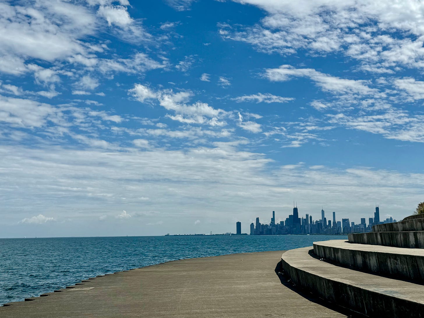 The Chicago skyline in the distance seen from a beach along Lake Michigan.