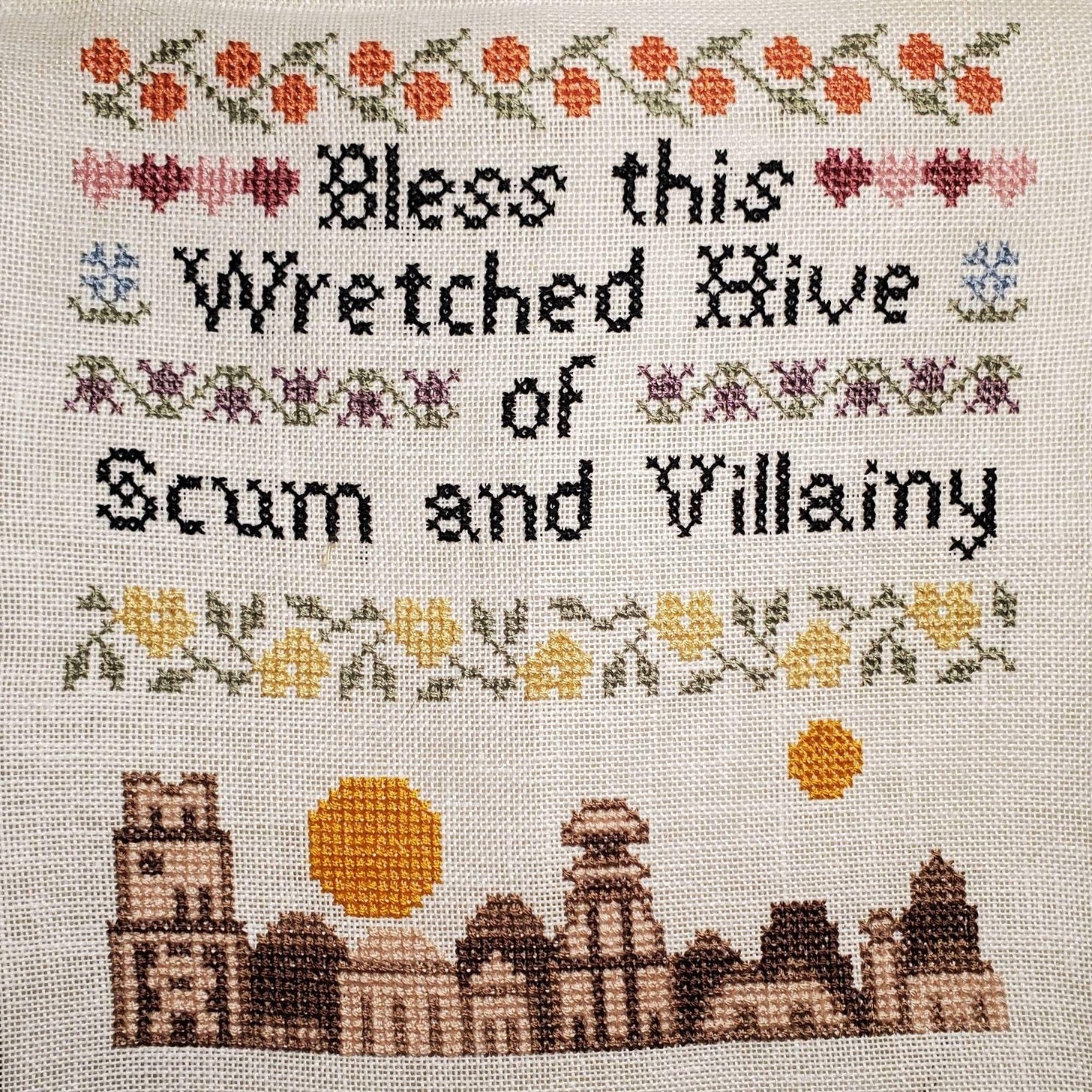 Needlepoint which reads: Bless This Wretched Hive of Scum and Villainy.