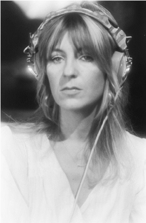 This may contain: a black and white photo of a woman with long hair wearing headphones on her ears