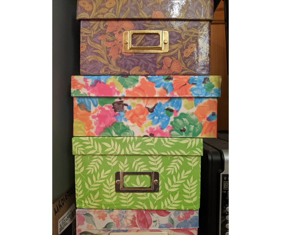 A stack of brightly colored flowered photo boxes, now empty