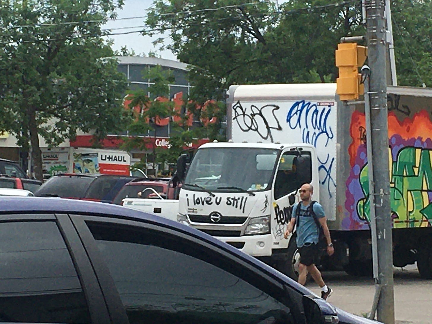 On a busy street in Toronto's Little Italy, a graffiti covered truck sports one phrase on the front: the scrawled words "I love you still"