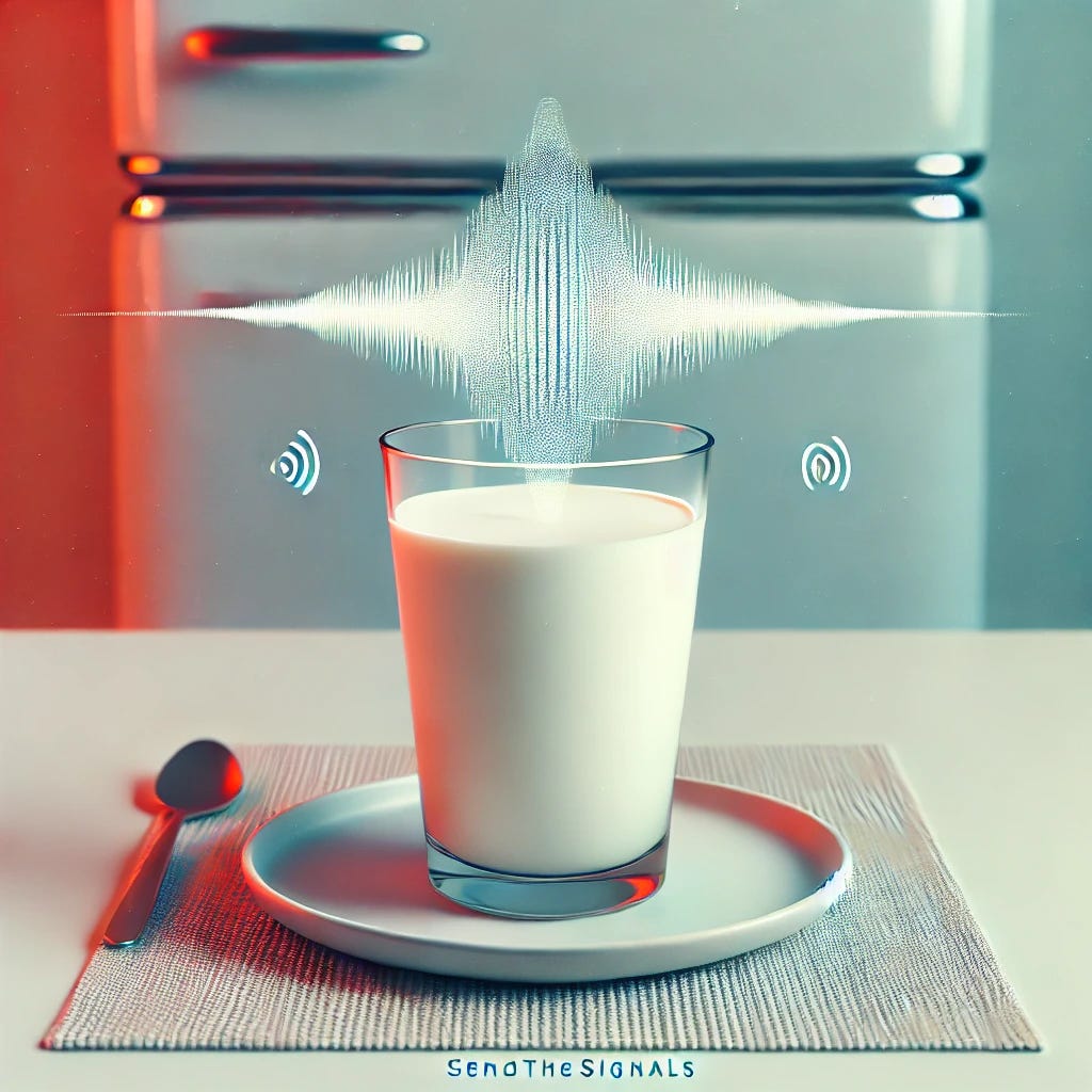 a glass of milk in a see-through cup sitting on an off-white plate on a table with an old-school refrigerator in the backdrop