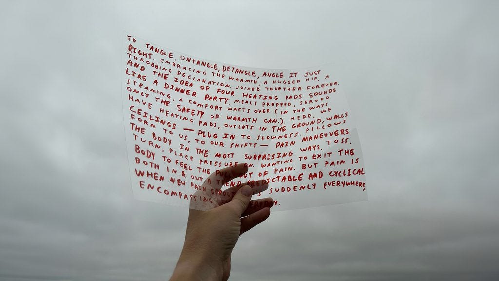 An artwork by Finn Shannon and Ezra Benus consisting of a photograph of a hand holding a piece of transparent film covered in words.