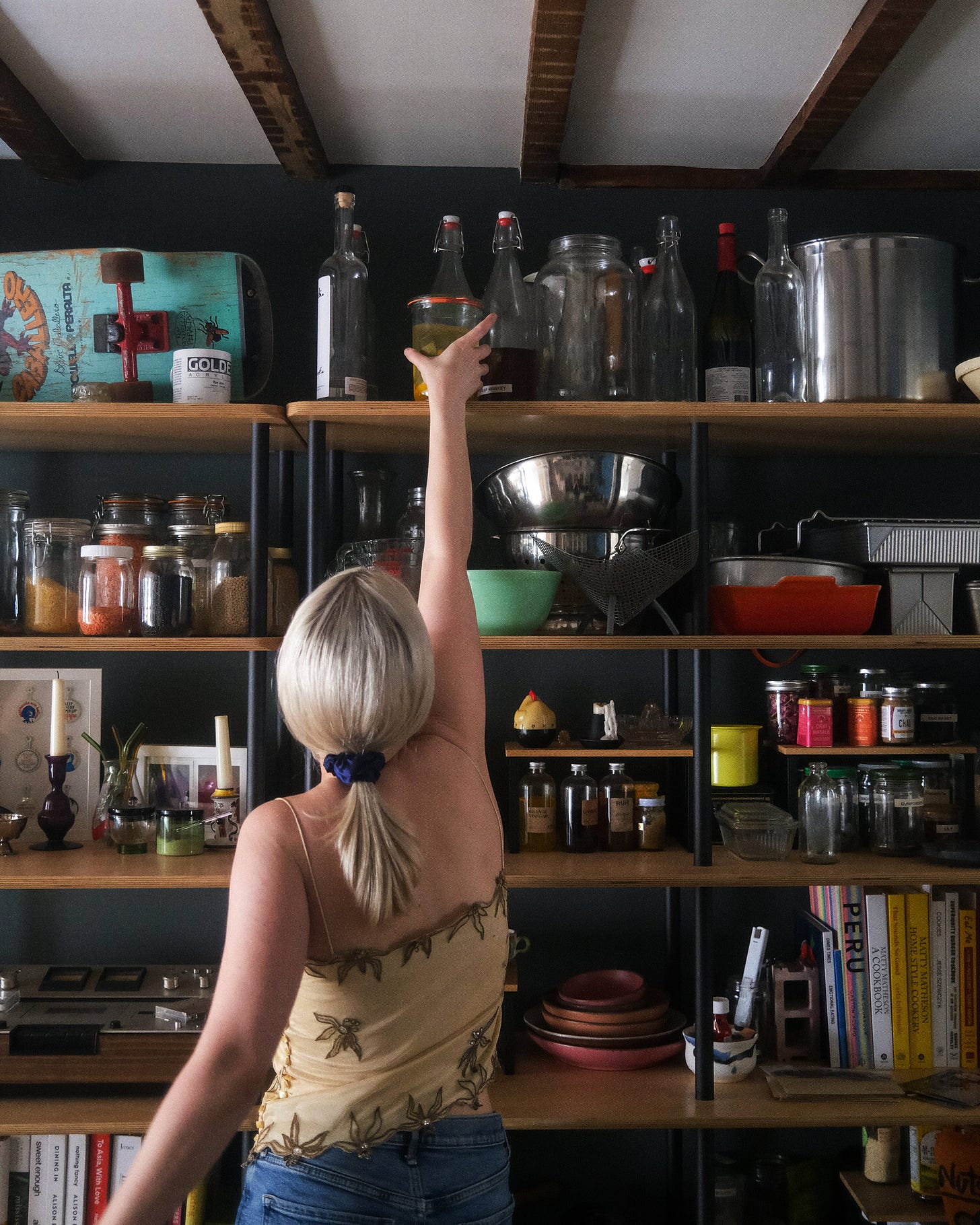 Photo of author reaching for jar on top of shelves