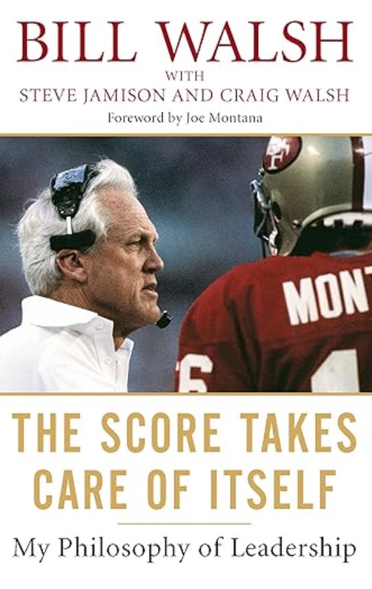 The cover of the book, "The Score Takes Care of Itself" by Bill Walsh. White background with red and gold text. A picture of Walsh with Joe Montana in the center photo.