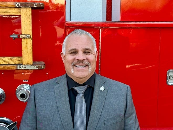 Fire Captain Freddy Escobar pictured in front of a fire truck 