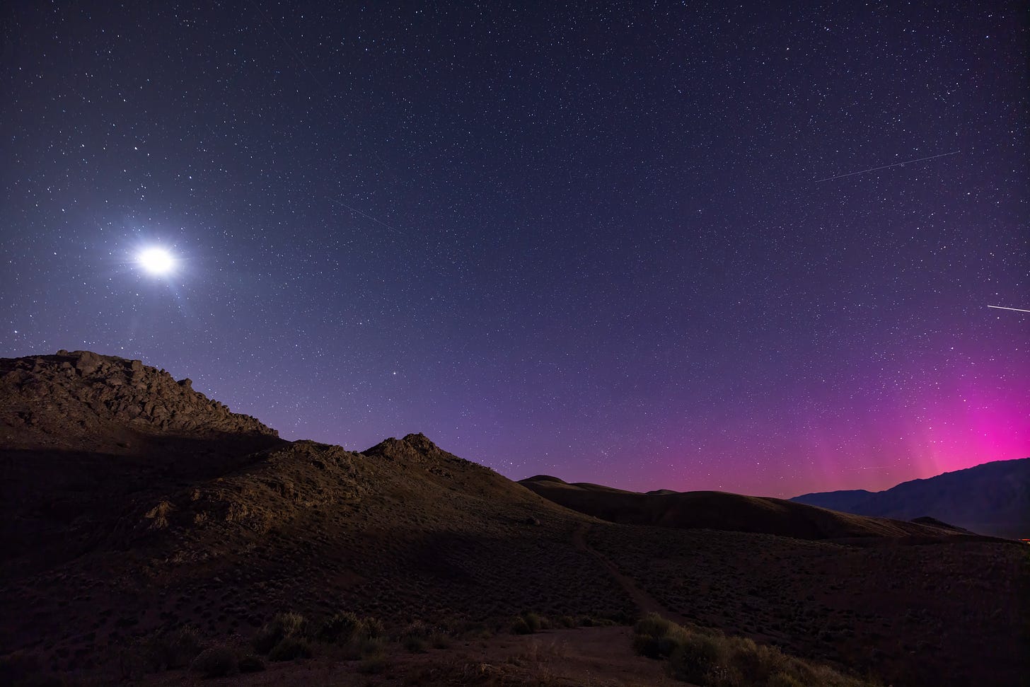 Aurora borealis make a rare appearance over Owens Valley,  as seen from near the Alabama Hills on May 12, 2024 outside of Lone Pine, California. (Photo by David McNew/Getty Images.)