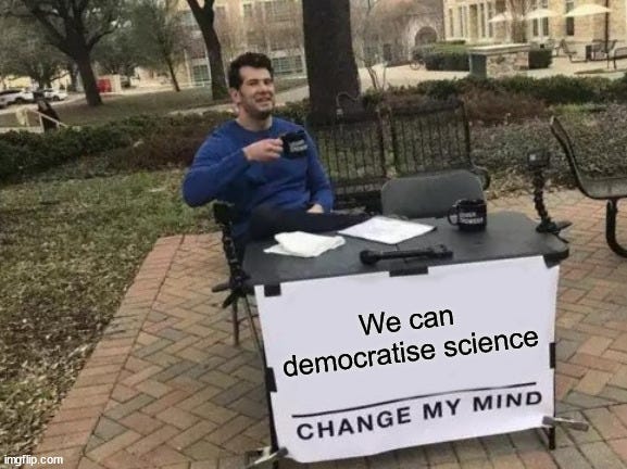Meme of man sitting at desk in park with cup of tea, on desk is sign that says at bottom We can democratise science: Change My Mind. Based on meme