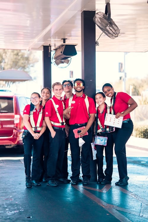 Free A diverse group of fast food employees smiling in uniforms outdoors Stock Photo