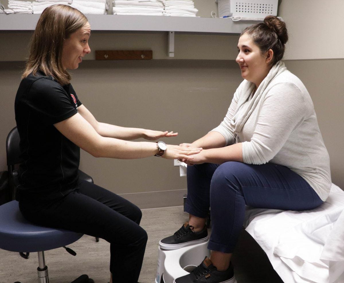 Rachel Shepherd, PT, DPT (left) explains the benefits of using a toilet stool to a patient at The... [+] Ohio State University Wexner Medical Center. (Photo: Courtesy of The Ohio State University Wexner Medical Center)