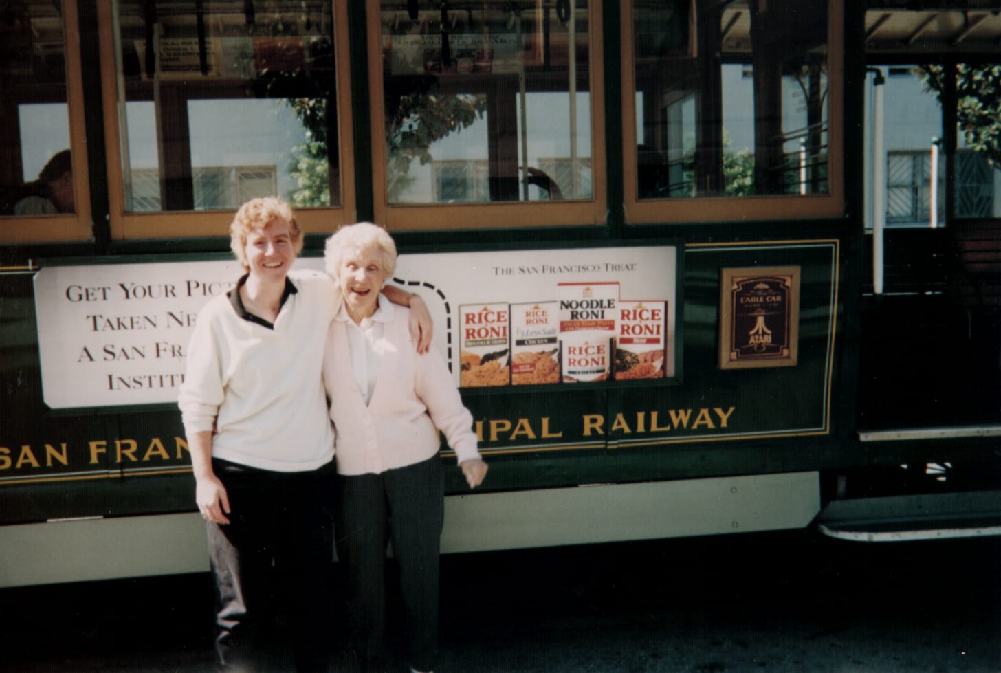 Mother and daughter hugging in front of a San Fransico Cable Car