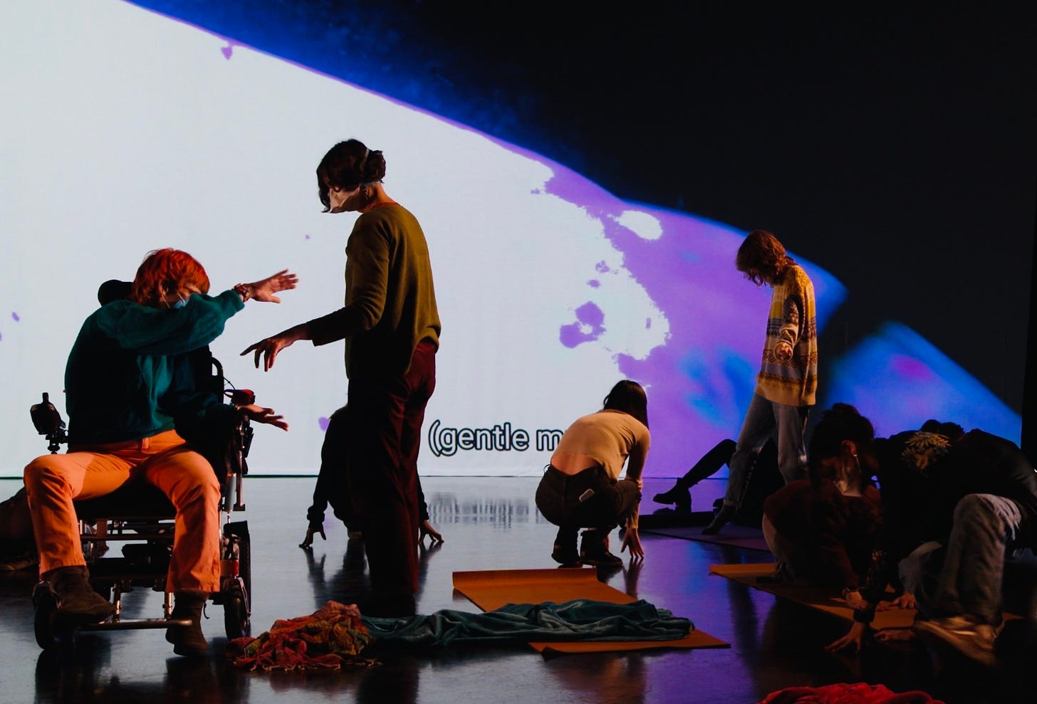 Community dance engagements in front of the Starship Somatics video projection: dancers, some in wheelchairs, some bipedal, moving together. 