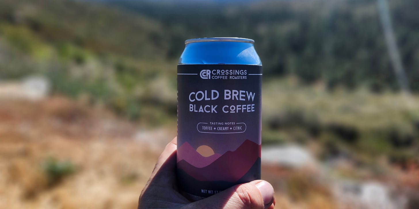 Close-up on a can of cold brew coffee against a blurred mount meadow background.