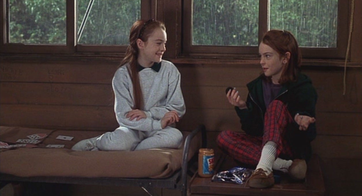 Movie still from The Parent Trap. Twin girls sit in a summer camp cabin with peanut butter and oreos
