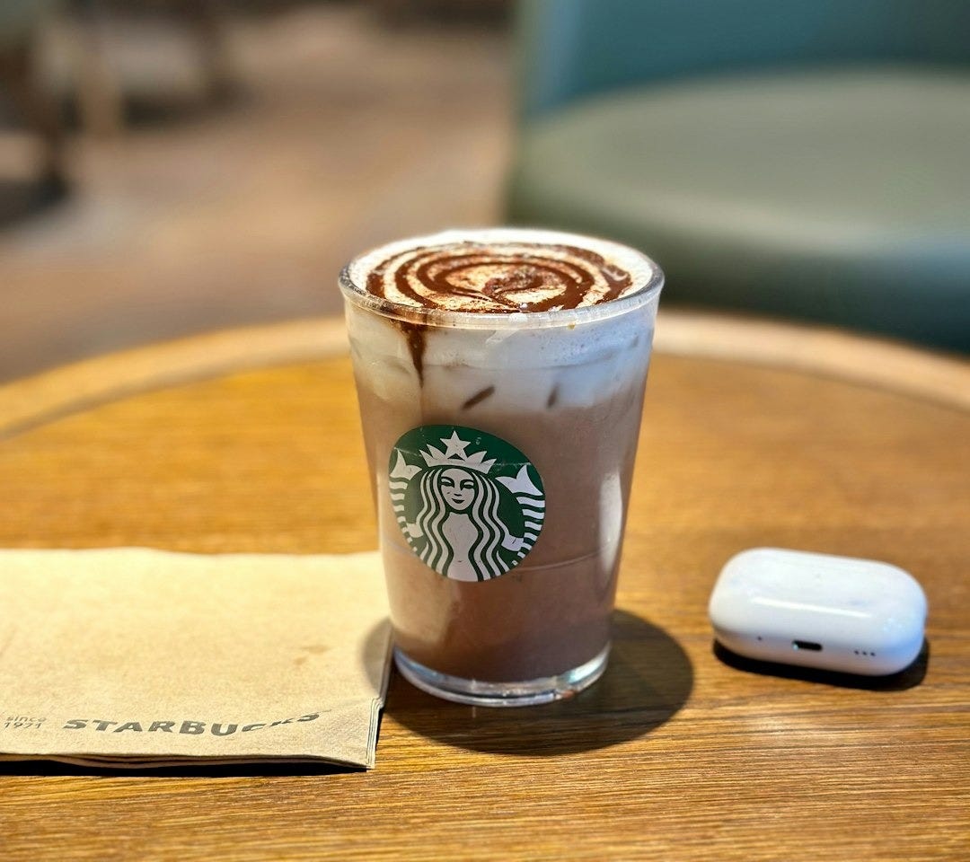 a cup of coffee sitting on top of a wooden table