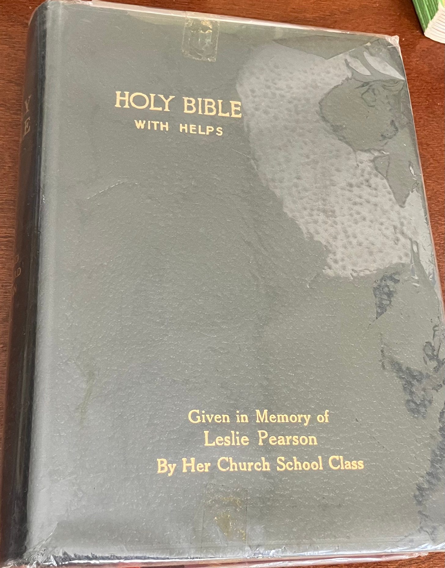 A Holy Bible with plastic wrapping embossed with the text Given in Memory of Leslie Pearson By Her Church School Class