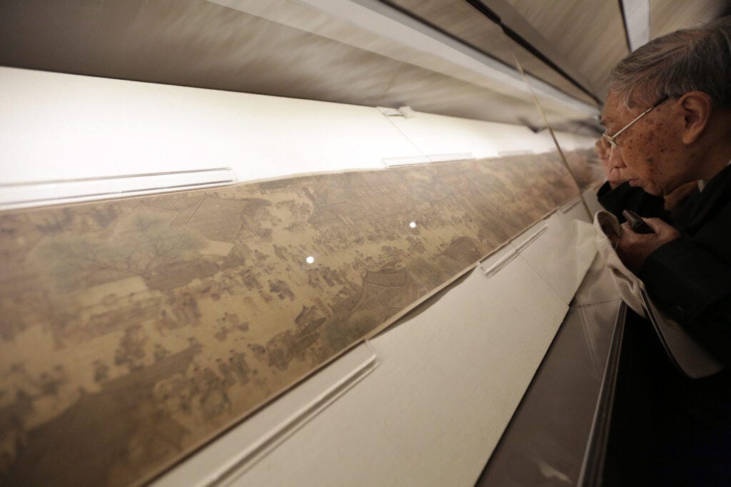 A visitor studies the scroll painting “Along the River During the Qingming Festival” at Beijing's Palace Museum in 2015. © How Hwee Young/EPA/ShutterstockChina Arts - Sep 2015. © How Hwee Young/EPA/Shutterstock