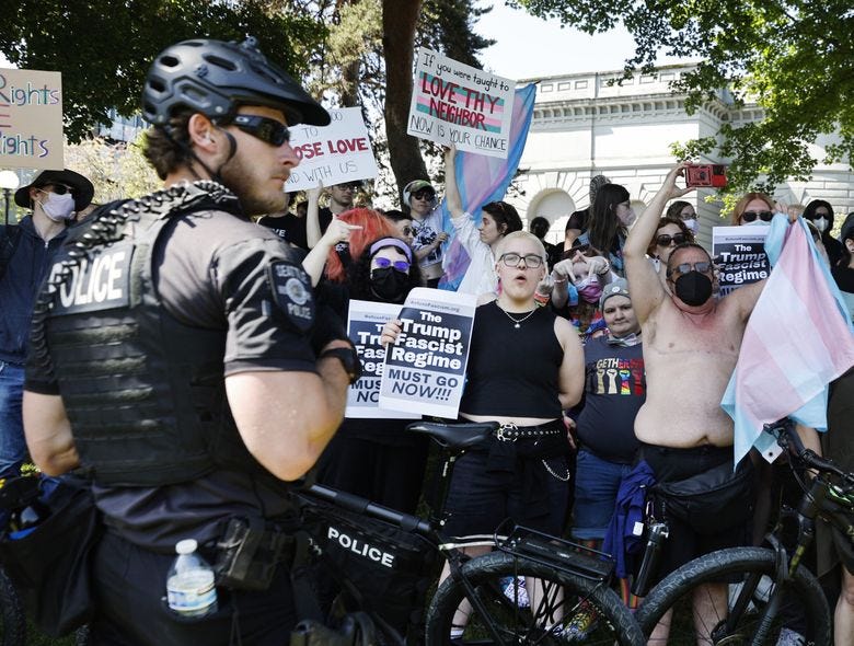 Protesters rally outside the “Mayday USA” event in Seattle’s Cal Anderson Park on Saturday. (Karen Ducey / The Seattle Times)